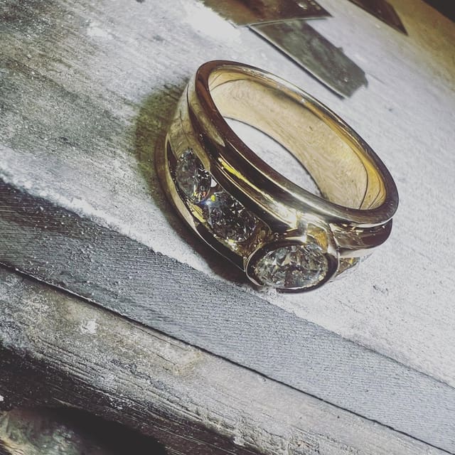 A ring we made, polished and set with stones, on the worn wood of our bench.