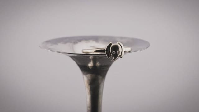 An elephant ring we made, set with two small stones, balanced on a mandrel.