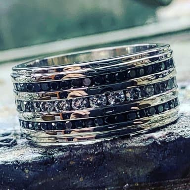 An eternity band set with black and white stones, on the bench.